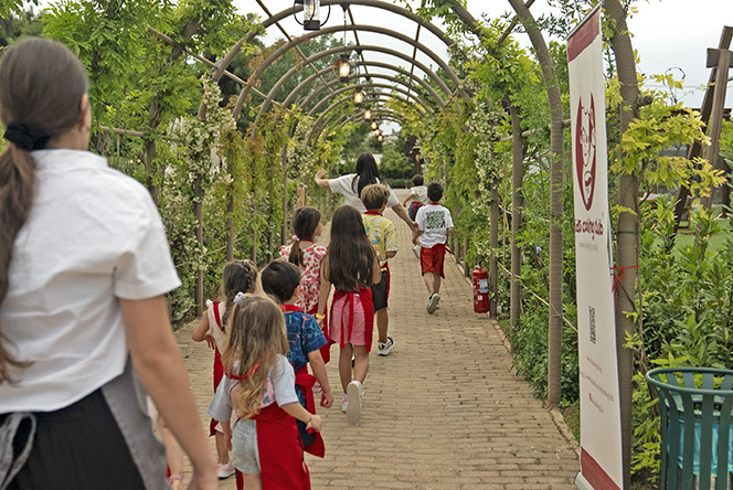 a lot of kids walking in a line on a pavement